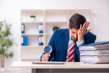 Young male employee unhappy with excessive work in the office