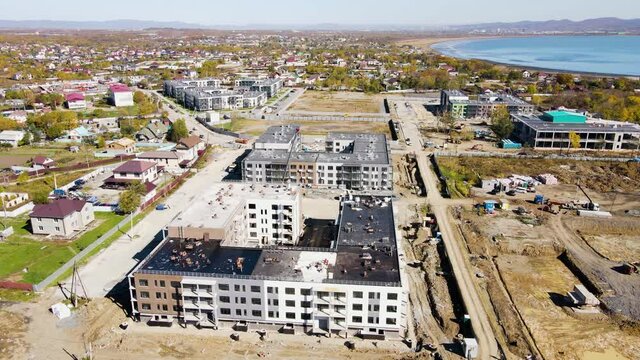 Panoramic shooting of the construction progress of new residential buildings. Construction of residential buildings. New microdistrict in the suburbs of Vladivostok. View from above.