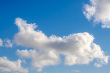 Naklejka na ściany i meble Beautiful white fluffy cloud floating in blue sky in sunny day, Cumulus are clouds which have flat bases and are often described as puffy, Horizon nature background.