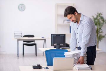Young male employee and too much work in the office