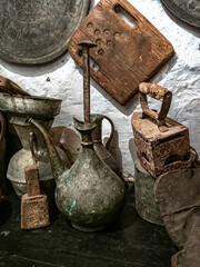 antique jugs, an antique iron and metal utensils along with decorative plates in a country house