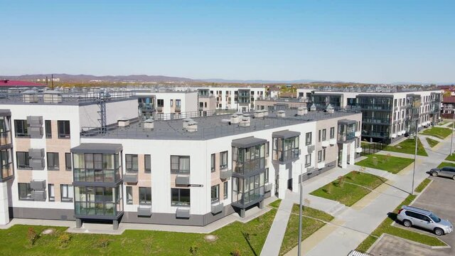 The camera zooms in and out over the rooftops of new residential buildings. New world district in the suburbs of Vladivostok. View from above.