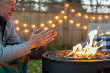 Man warming his hands by a fire in fall - 466601076