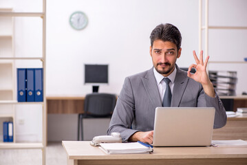 Fototapeta premium Young male employee working in the office