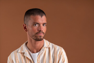 Fototapeta premium Studio portrait of a young man on a brown background