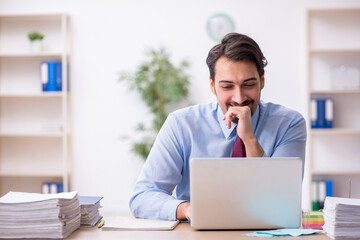 Young male employee and too much work in the office