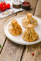 Fried Georgian khinkali on white plate on wooden table