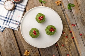 pkhali of spinach, georgian cuisine on white plate on wooden table top view