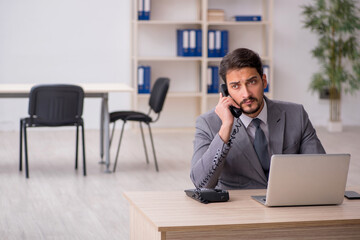 Young male employee and too much work in the office