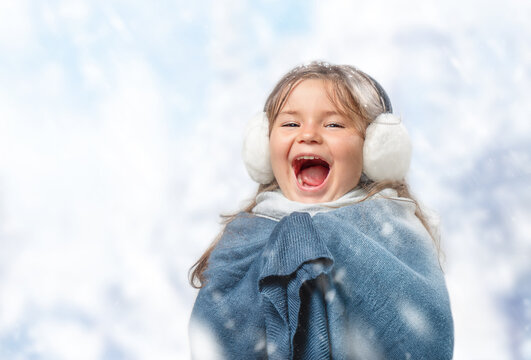 Child girl in earmuff screaming with joy