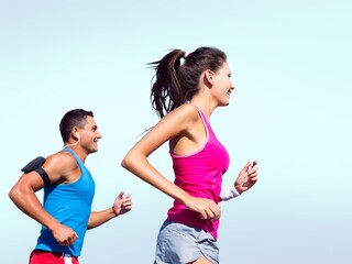 Happy young man and woman in sportswear running together
