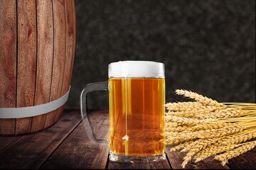 mug of beer, wheat ears, hops on a wooden background