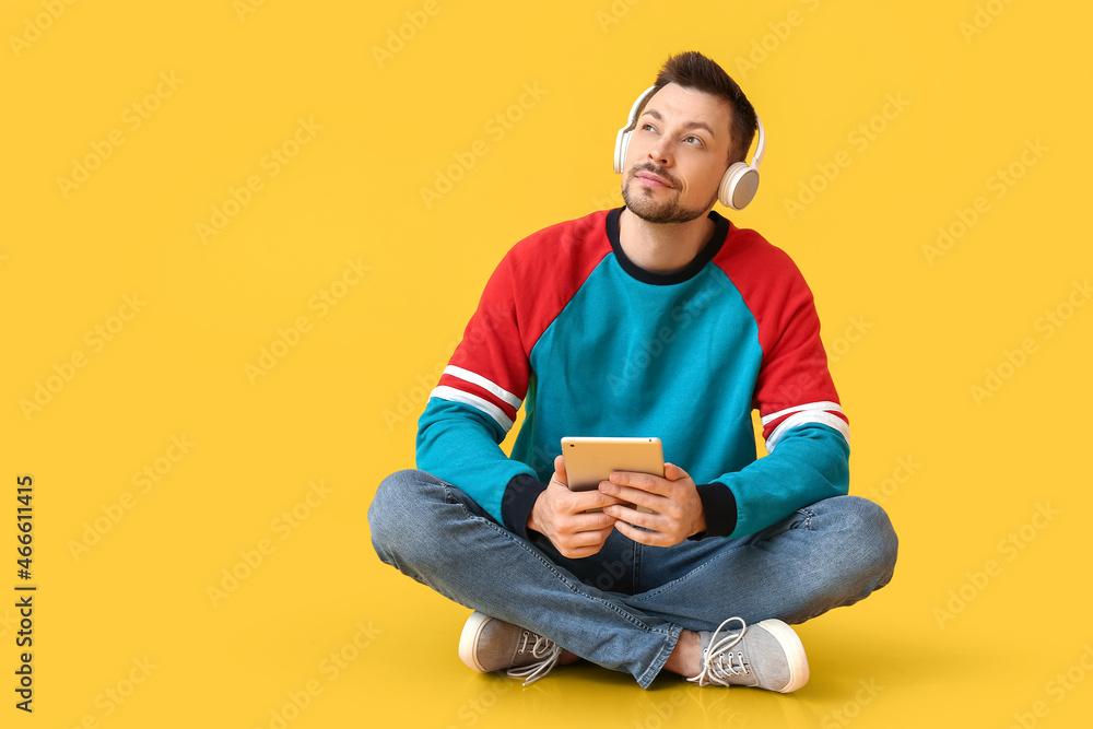 Poster man with tablet computer and headphones on color background