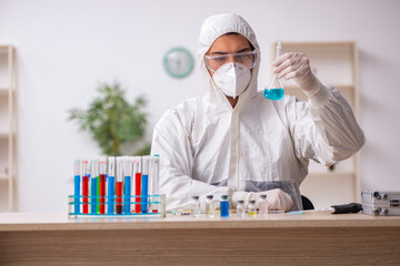 Young male chemist working at the lab during pandemic