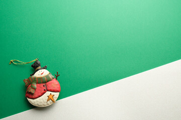 snowman ornament on green and white background