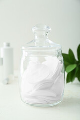 Fototapeta na wymiar Glass jar with clean cotton pads on light table