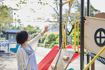 子どもと遊具で遊ぶベテラン保育士