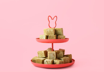 Stand with tasty hojicha marshmallows on pink background