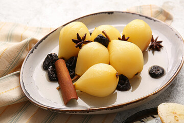Dish with delicious poached pears, prunes, anise and cinnamon on light table
