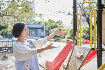 子どもと遊具で遊ぶベテラン保育士