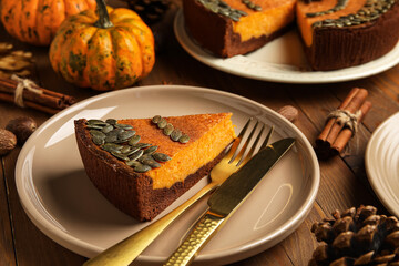 Piece of delicious pumpkin pie on wooden background