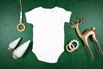 Baby romper jumpsuit onesie product mockup. Christmas theme SVG craft product mockup styled with gift with buffalo plaid bow and farmhouse style gnomes against a green background.