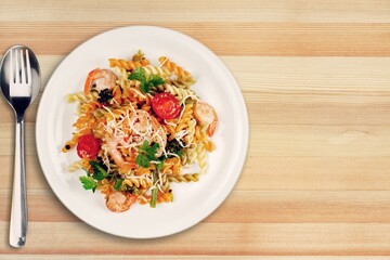 Pasta with cherry tomatoes, cheese and basil on a light plate