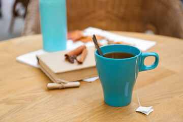 Blue cup with tea bag on table in cafe outdoors