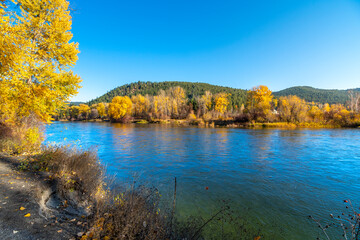 View of the Wenatchee River at autumn with fall colors on the leaves from Blackbird Island at Leavenworth, Washington, USA.