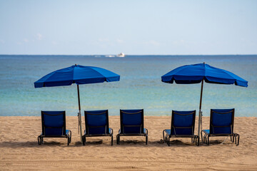 Blue lounge chairs and umbrellas on the beach