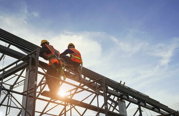 A construction teamwork in the construction of metall roof structures on construction site and...