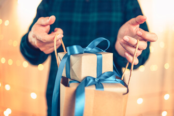 Hands holding gift box, present on the table and light of bokeh background. Valentine's Day,...