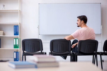 Young male teacher in the classroom during pandemic