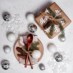 Christmas background with New Year decorations and set table. Spoon and fork, gift on a black chalk board with place for text.