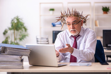 Fototapeta premium Old male employee wearing prickly wreath on head