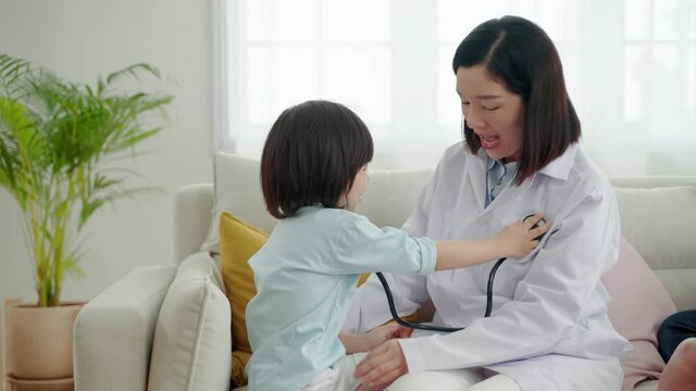 Asian family relationships, father, mother and son having fun playing doctor and patient in their home.
