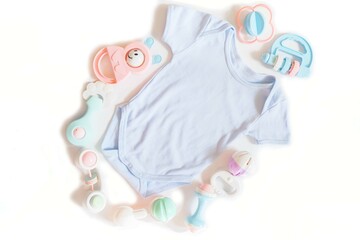 Newborn baby clothing and lots of colorful rattle toys on white background.childhood, beginning childhood and Childcare concept.