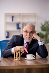Old male employee in time management concept