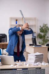 Old male employee unhappy with excessive work in the office