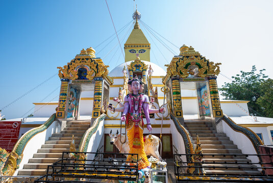 Hindu god statue in front of the mock up of Boudhanath stupa located at Brahma Dhada Buddha Stan in Chom Thong district of Chiang Mai province, Thailand.