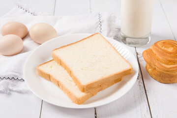 Sliced bread bake and milk on wood background. Simple breakfast