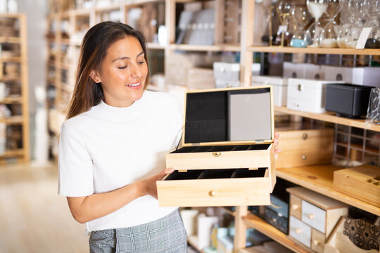 Latino american attractive woman looking for functional jewelry box in decor store