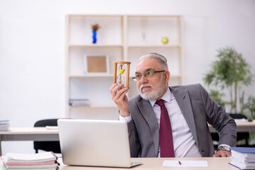 Fototapeta premium Old male employee in time management concept