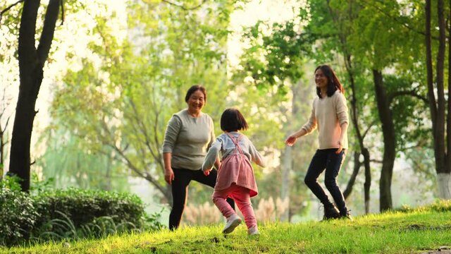 three generation asian family playing in the sunny autumn park senior asian woman with daughter and granddaughter relax together lifestyles outdoor in the nature