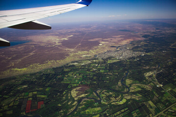 Viaje en Avión .Volando sobre la ciudad hacia el destino. Paisaje sobre las nubes. Ala de Avión