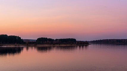 A beautiful view of the river from the high bank during sunset. Autumn landscape.