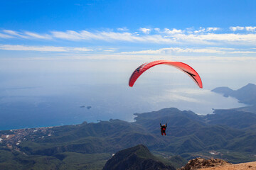 Paragliders flying from a top of Tahtali mountain near Kemer, Antalya Province in Turkey. Concept of active lifestyle and extreme sport adventure