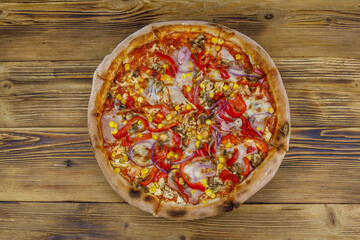 Delicious fresh pizza on a wooden table. Top view