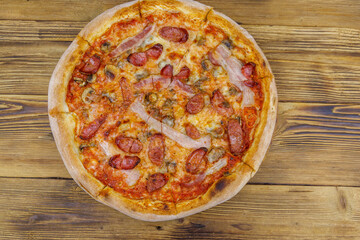 Delicious fresh pizza with sausage, mushrooms and cheese on a wooden table. Top view