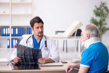 Obraz premium Old male patient visiting young male doctor radiologist